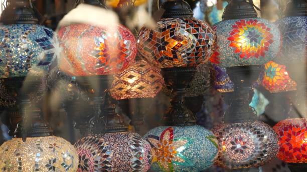 istock Colourful turkish lamps from glass mosaic glowing. Arabic multi colored authentic retro style lights. Many illuminated moroccan craft lanterns. Oriental islamic middle eastern decor. Shiny folk shop 1257244084