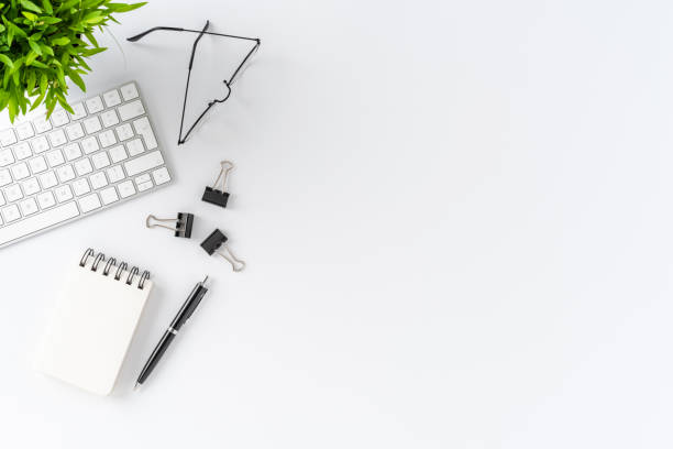 istock Office desktop with modern computer keyboard and accessories on white background. Elegant workspace. Top view 1257244148