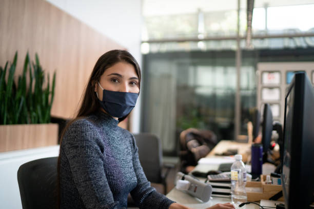 Portrait of lobby receptionist wearing face mask Portrait of lobby receptionist wearing face mask reception desk photos stock pictures, royalty-free photos & images