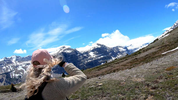 istock Woman hikes up windy mountain ridge 1257246011