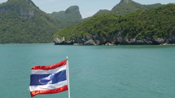 grupo de islas en el océano en el parque marino nacional ang thong. archipiélago en el golfo de tailandia. idílico fondo natural de mar turquesa con espacio de copia. ondeando la bandera como símbolo nacional en el barco. - ang thong islands fotografías e imágenes de stock