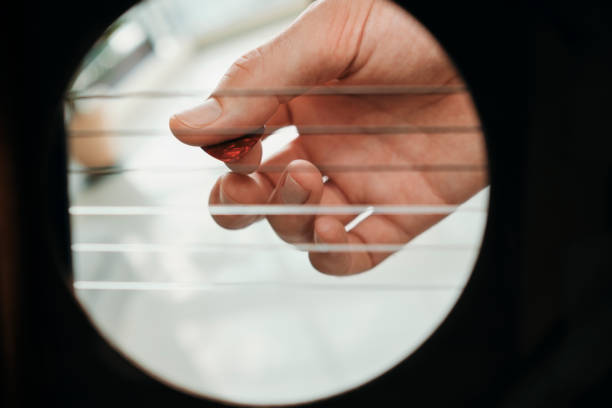 istock Hand Of Man Playing Acoustic Guitar Viewed From Inside Hole 1257248782