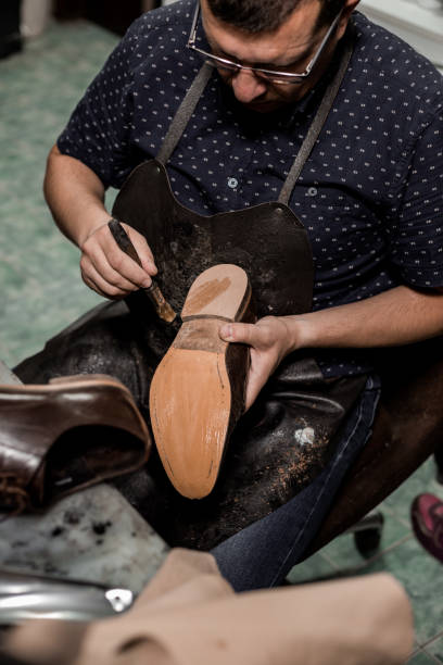 istock Cobbler repairing shoes 1257248805