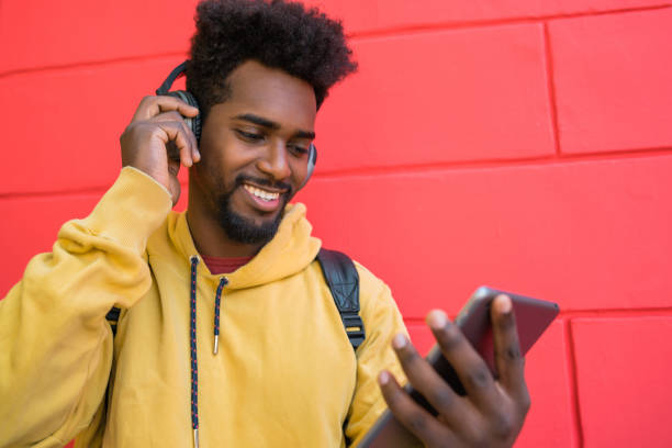 istock Afro man using his digital tablet with headphones. 1257249190