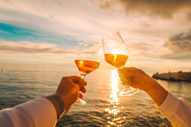 istock couple resting on sunset at sea beach and drinking wine 1257250686