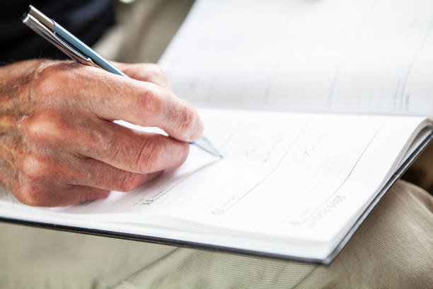 istock Male senior hand writing in a diary 1257253132
