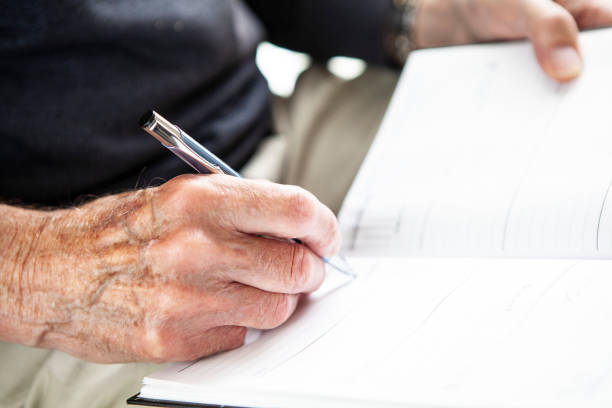 istock Male senior hand writing in a diary 1257253135