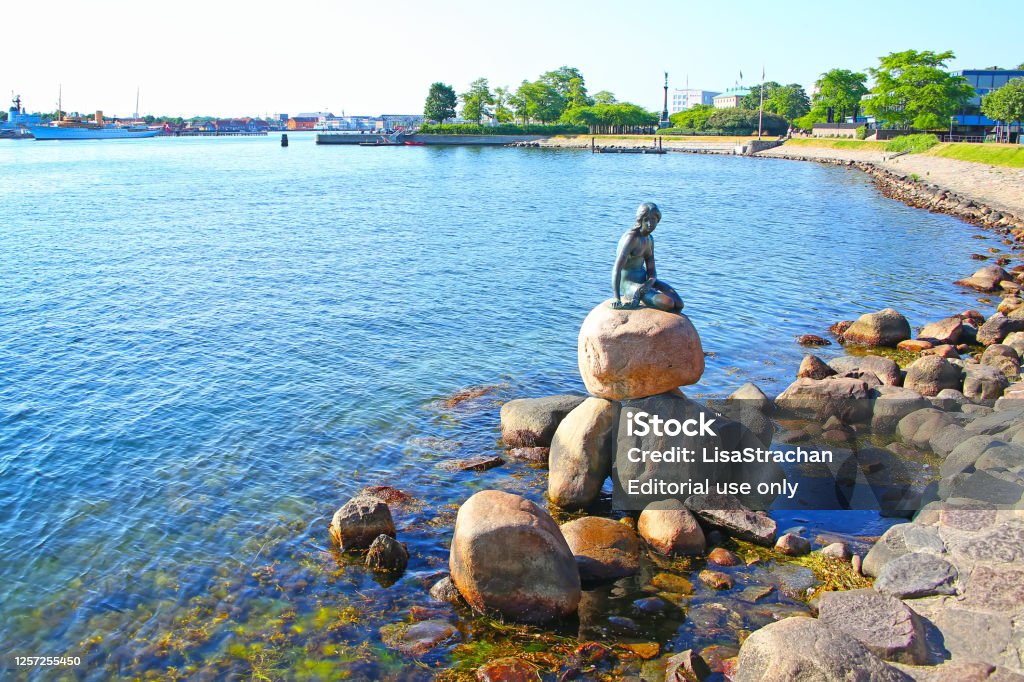 Little mermaid statue, Copenhagen, Denmark. Langelinie promenade with the iconic little mermaid statue & landmark in the foreground and the harbour in the background, Copenhagen, Denmark. Copenhagen Stock Photo
