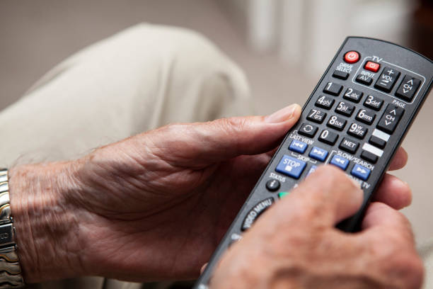 istock Male senior hands holding a tv remote control 1257256128