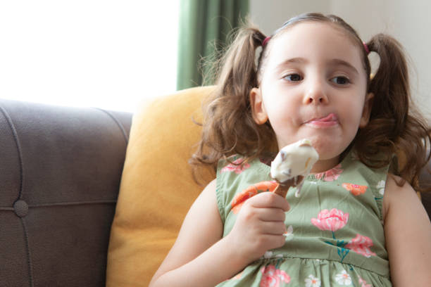 istock Cute girl eating ice cream 1257257243
