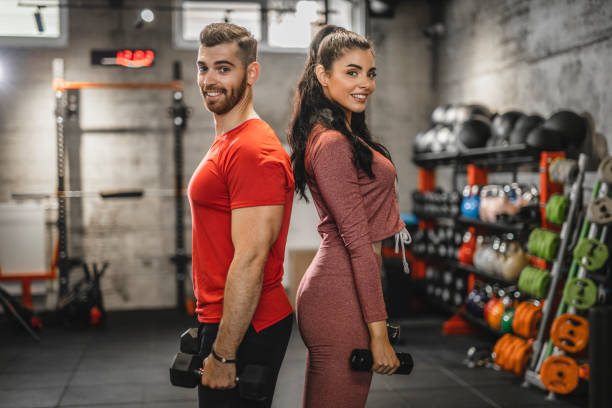 Portrait of two people having weight training with dumbbells at the gym Portrait of two people having weight training with dumbbells at the gym barbel stock pictures, royalty-free photos & images