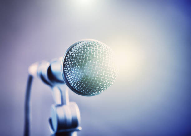 istock Dazzling stage lights surround a dynamic vocal microphone 1257260102