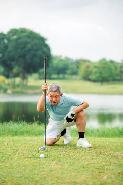 istock Asian chinese active senior golfer line up golf ball with putter on green course. 1257262552
