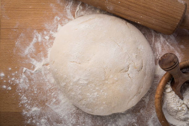 istock Freshly prepared yeast dough for pizza or bread on wooden background. 1257262946