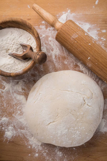 istock Freshly prepared yeast dough for pizza or bread on wooden background. 1257262954