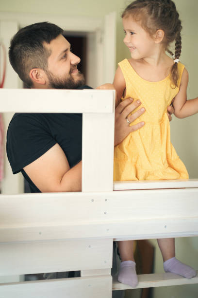 istock Young man with his daughter assembling furniture at home 1257263165