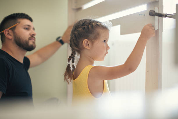 istock Young man with his daughter assembling furniture at home 1257263879