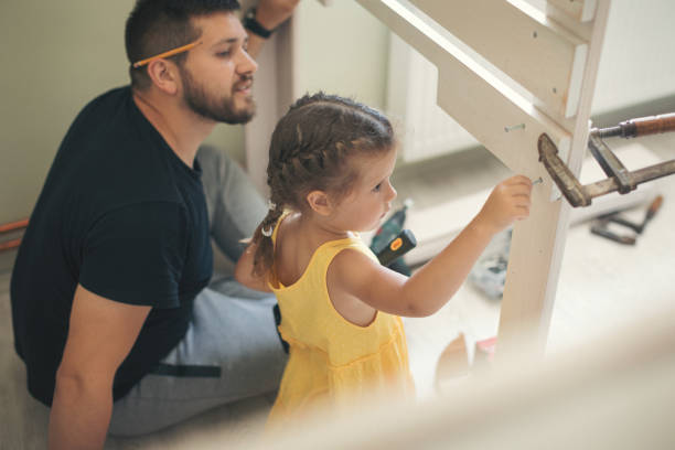 istock Young man with his daughter assembling furniture at home 1257263892