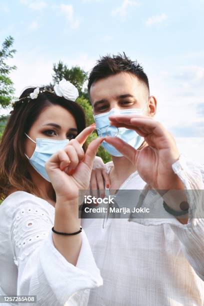 Just Married Couple Holding Their Wedding Rings Wearing Face Masks Stock Photo - Download Image Now