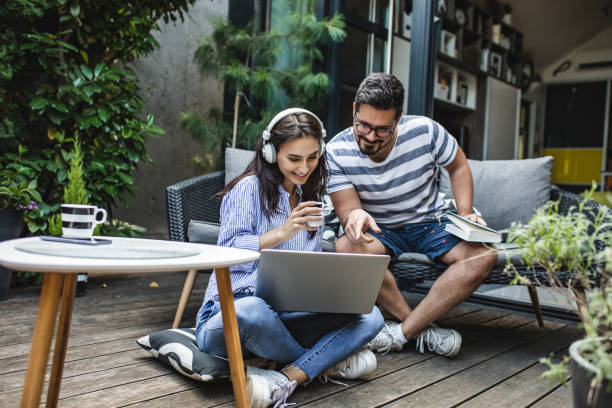 молодая пара расслабляющая пара дома - e commerce couple working at home internet стоковые фото и изображения