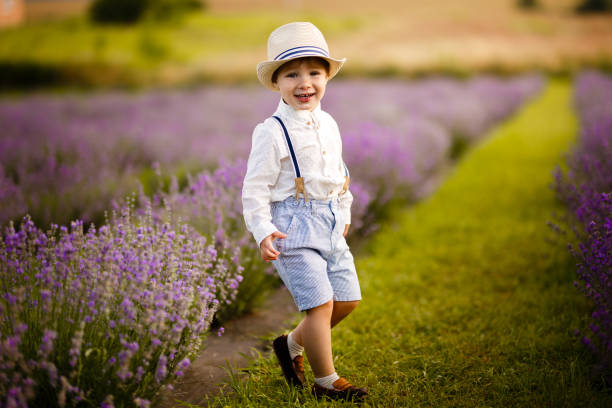 istock Little boy walking on a lavender field. In a stylish hat. 1257268188