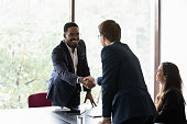 Multiethnic business partners start group meeting shake hands express regard