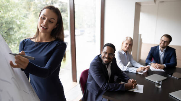 istock Millennial coach using flipchart give presentation to multiethnic businesspeople 1257268356