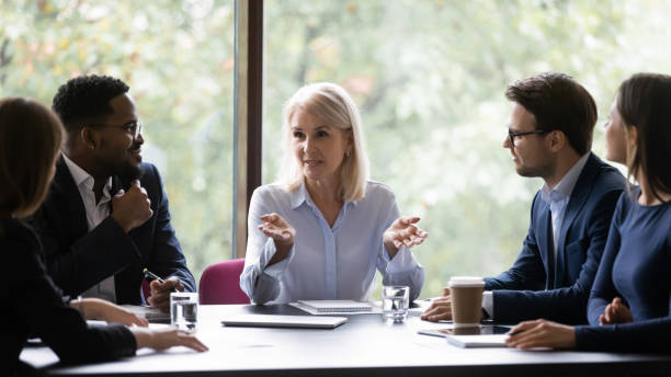 istock Mature leader boss give helpful information to young diverse professionals 1257268363