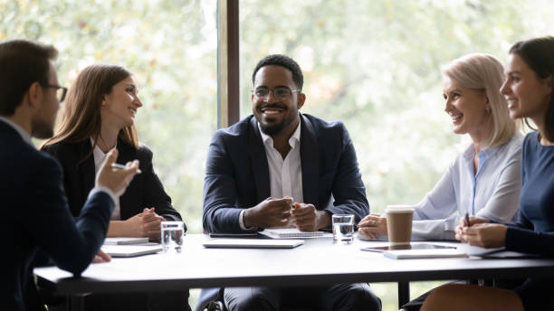 istock Five multiethnic company staff gather together talking planning future project 1257268369