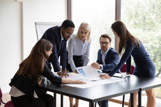 istock Five diverse employees make project research at group meeting 1257268381