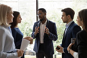 istock Confident African male leader telling diverse colleagues about new project 1257268399