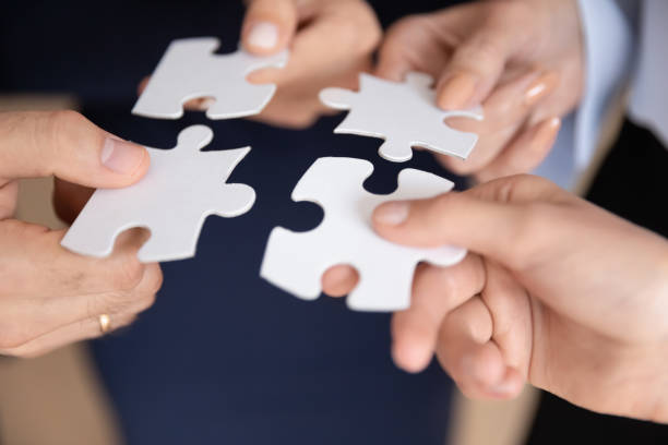istock Closeup hands holding white pieces of puzzles find right solution 1257268424
