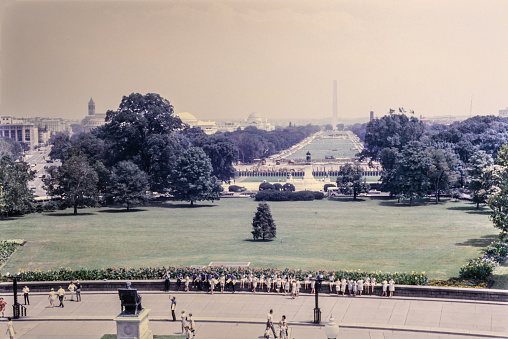 The Washington National Mall during the 1950's. The long, grassy National Mall is home to iconic monuments including the Lincoln Memorial and the Washington Monument. At the eastern end is the domed U.S. Capitol, and the White House is to the north. It's also flanked by Smithsonian museums, and its lawns and pathways are often crowded with school groups, joggers and softball teams. Nearby, the Tidal Basin reservoir is known for its blossoming cherry trees. Copyright has expired on this artwork. Digitally restored. Historic photos shows the U.S. Capitol in 1950 and its surrounding areas of Washington D.C.