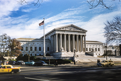 The Supreme Court Building houses the Supreme Court of the United States. Completed in 1935, it is in Washington, D.C. at 1 First Street, NE, in the block immediately east of the United States Capitol. The building is managed by the Architect of the Capitol. On May 4, 1987, the Supreme Court Building was designated a National Historic Landmark. Copyright has expired on this artwork. Digitally restored. Historic photos shows the U.S. Capitol in 1950 and its surrounding areas of Washington D.C.