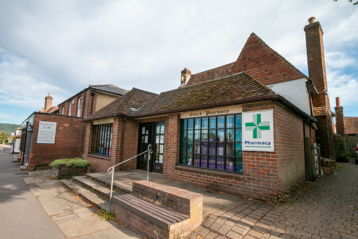 Otford Pharmacy in Kent, England. This is a privately owned business. A cafe is in the background.