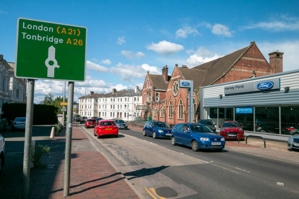 Northampton, UK - September 06 2025: Pedestrians stroll along the sunlit Gold Street pavement lined with various shops, cafes, and everyday city life under a partly cloudy sky with sunlight in autumn