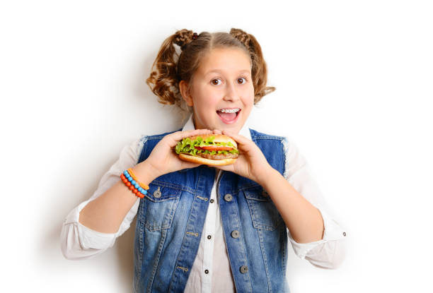 istock schoolgirl eating burger on white background 1257273744
