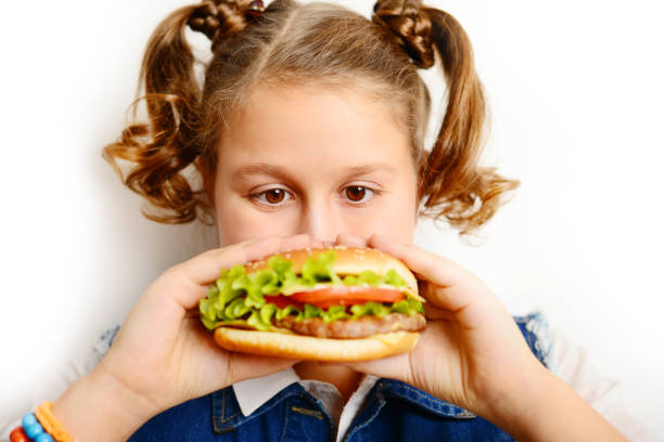 istock schoolgirl eating burger on white background 1257274303