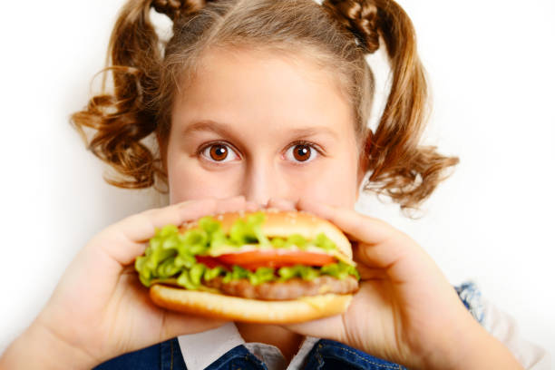 istock schoolgirl eating burger on white background 1257274335