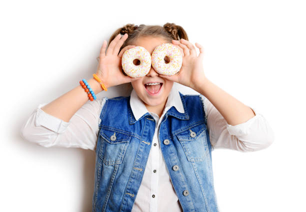 istock schoolgirl eating donut on white background 1257274360