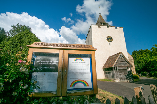 St Bartholomews Church in Otford, England, with named details and illustrations on the church notice at the gate. There are rainbows to depict Covid-19 and a Black Lives Matter hash tag and statement