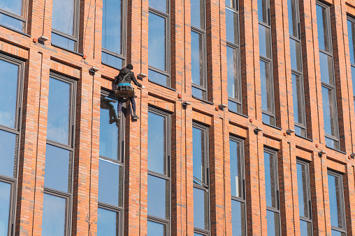 Saint Petersburg, Russia - April 7, 2020: a rope access technician works on the highrise building's facade.
