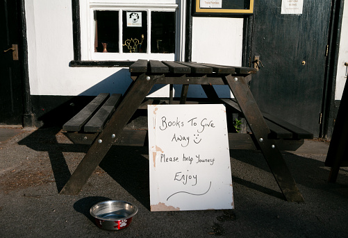Ye Olde George Inn in Shoreham, England, with a books to giveaway sign and a coin collection dish