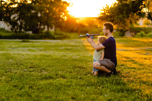 istock Happy toddler boy having fun with his father while playing with airplane toy 1257276904