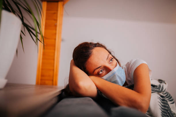 istock Sick woman with face protective mask lying in bed 1257280376