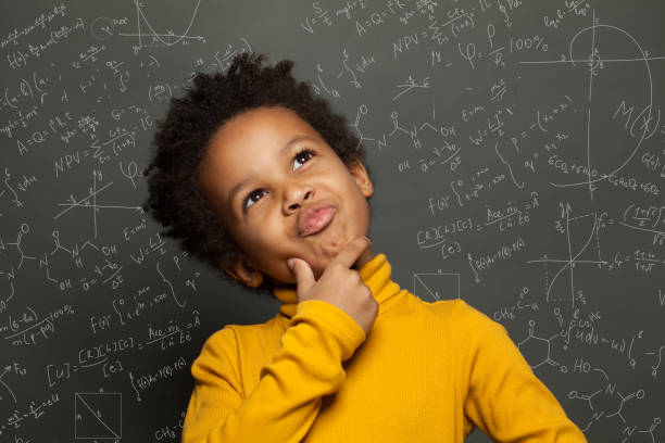 istock Clever black child thinking on chalkboard background with science formulas 1257280885
