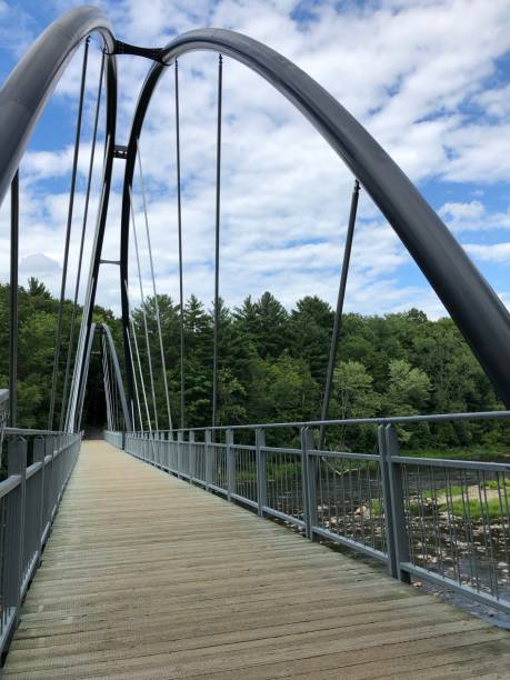 istock Suspension bridge over the river in perspective on the left side 1257280921
