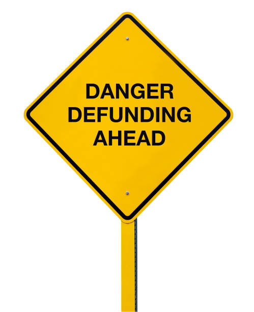istock Danger Defunding Ahead Road Sign isolated against a white background 1257282216