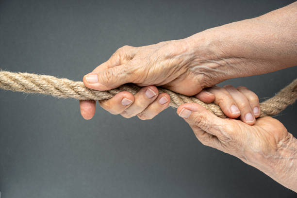 istock Elderly woman wrinkled hands pull the rope 1257285161