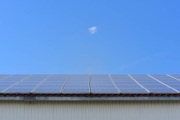 istock Background with blue sky and an industrial building on which is a solar system 1257285646